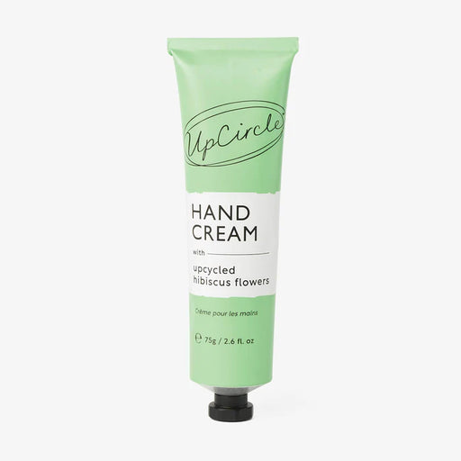 Green tube of UpCircle hand cream with hibiscus flowers